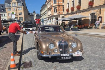 Von Jaguar bis Trabant: Oldtimer-Rallye führt durchs Erzgebirge - Joachim Kleinschnitz fertigte am Annaberger Markt auch den Jaguar S-Type aus dem Jahr 1966 ab, mit dem Paul Kleger und Urs Buchli aus Zürich an der Historic Rallye Erzgebirge teilnehmen.