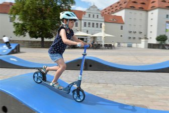 Von Laufrad bis „Klappi“: Wie kommt der Freiluftsport in Freiberg an? - Wie ein Profi rollt Lea Breitfeld (7) aus Freiberg schon mit ihrem Roller über den aufgebauten Pumptrack auf dem Schlossplatz in Freiberg.