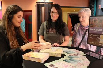 Großer Andrang bei Lesung im Zwickauer Kino: Was hinter dem Hype um diese Autorin steckt - Autorin Gabriella Santos de Lima (l.) beim Signieren der mitgebrachten Bücher von Nancy Schuhknecht, die mit Mutter Ulrike zur Lesung ins „Astoria“ gekommen ist.