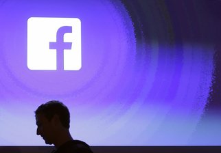 Mark Zuckerberg, Gründer von Facebook, geht am Firmensitz an einem leuchtenden Facebook-Logo vorbei. Vor 20 Jahren revolutionierte der damalige Harvard-Student mit der Gründung eines Studierendennetzwerks die zwischenmenschliche Kommunikation. Wahr bleibt indes: Wo Facebook viel Licht in die Welt schickt, da entsteht auch viel Schatten. 
