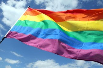Eine Regenbogenfahne weht im Wind.