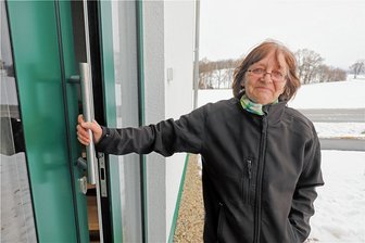 Vorfreude und Sorgen in Oberbobritzsch: Nach vielen Jahren neuer Lebensmittelmarkt gebaut - Rita Schulz an ihrem Einfamilienhaus an der Pretzschendorfer Straße, das sie mit ihrem Mann und einer Katze bewohnt. Im Hintergrund das Areal, auf dem der Netto-Markt entstehen soll.