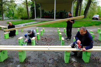 Vorm Pavillon im Park werden Bänke saniert - 