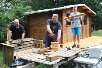 Wachstumsprogramm: Erster Gemeinschaftsgarten in Flöha nimmt Gestalt an - Oleksandr Bondarenko, Oleksandr Sarbiatov und Mykola Sarbiatov (von links) aus der Ukraine haben aus dem Palettenholz schon mal eine Gartenbank gezimmert.