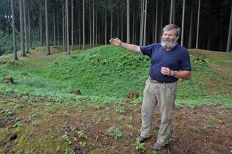 Wälle und Hügel zeugen von der Bergbaustadt im Hohen Forst - Wolfgang Prehl zeigt auf die Geländestruktur. Der kreisförmige Schutzwall um die ehemalige Turmhügelburg ist noch deutlich erkennbar.