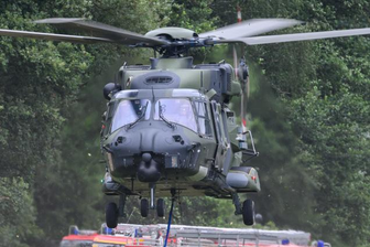 Waldbrand Sächsische Schweiz: Feuerwehrleute aus dem Erzgebirge in Alarmbereitschaft - Auch die Bundeswehr unterstützt mit ihren Kräften die Brandbekämpfung im Naturpark - hier im Foto ein Hubschrauber, der mit einem Löschwasser-Außenlastbehälter am Ufer der Elbe abhebt.