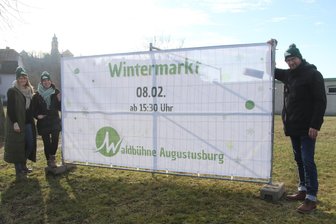 Waldbühnenverein Augustusburg veranstaltet Wintermarkt mit Eisstockschießen - Die Vereinsmitglieder Jule Gebelein, Maria Bachnick und Sebastian Frank (v. l.) vor einem der Werbebanner, die extra aufgestellt wurden.