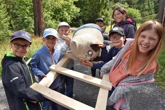 Waldschule Am Kunnerstein: Auf der Jagd nach einem Stoffschwein - Waldschule Kunnerstein: Die Ferienkinder aus Erlau haben ein „Schwein“ zur Strecke gebracht und transportieren es auf einer selbst gebauten Leiter.