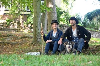 Wandergesellen auf Schloss Wolkenburg: Drei Jahre ohne Handy, Geld und Unterkunft – warum junge Leute auf Wanderschaft gehen - Schmiedegesellin Meta Högg mit Hund Loki und Schlossergeselle Finn sind derzeit auf einer Wandergesellenbaustelle auf dem Schloss Wolkenburg. Dort verfolgen die beiden ein ganz bestimmtes Ziel.