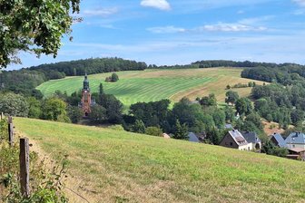 Wandern auf dem Chemnitzer Höhenweg: Erkundungstour am Rande der Stadt - Bevor die Wanderer final nach Harthau absteigen, haben sie einen schönen Blick in den Stadtteil. Die wuchtige Lutherkirche dominiert das Tal..