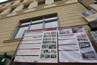 Wandernder Bauzaun: Verlorene Orte und Disko-Nächte - Begleiter der Museumsarbeit in Lichtenstein seit Pandemiebeginn: Der "Wandernde Bauzaun", hier am Neumarkt vor der "Goldnen Sonne". Die Fassade konnte kürzlich nach historischem Vorbild saniert werden.