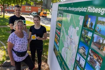 Wanderregion um Auerbach jetzt komplett neu erschlossen - Jan Gabriel und Carolin Schmidt (hinten) von der Stadtverwaltung Auerbach haben im Sommer zusammen mit Anita Kunz vom Heimatverein Rebesgrün Wanderwege in der Auerbacher Ortschaft markiert. Start und Ziel ist der Wanderparkplatz am neuen Dorfzentrum, wo auf einer Schautafel alle Infos zu den Touren zu finden sind. Auch in Beerheide, Vogelsgrün-Schnarrtanne und Reumtengrün finden Urlauber und interessierte Einheimische lokale Tourenvorschläge auf derartigen Informationstafeln. Ergänzend dazu hat die Touristinfo Auerbach Faltblätter mit den Wandertouren für die Ortsteile erstellt, die zurzeit im Druck sind.