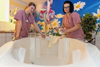 Wanne erleichtert die Geburt für Mutter und Kind - Hebammen-Studentin Marie Tröger (links) und Antje Kovacs, leitende Hebamme, bereiten ein Bad für eine Geburt vor.