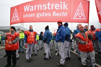 Warnstreiks bei Volkswagen: Die Uhr tickt - "Warnstreik - unser gutes Recht" steht auf einem Banner von Beschäftigten vor dem VW-Werk in Zwickau.