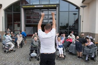 Warten und hoffen in Dresden: Hunderte harren in Notunterkunft aus - Morgengymnastik auf dem Gelände der Dresdner Messe vor einer Notunterkunft