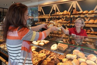 Warum Bäckereien die Preise anheben - Kundin Katja Borchardt kauft im sogenannten Genussplatz der Mühlenbäckerei Clauß in Zwickau bei Fachverkäuferin Sylvia Hausotto Doppelbrötchen für 70 Cent pro Stück. 
