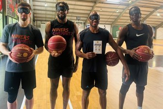 Warum beim nächsten Heimspiel der Niners Chemnitz alle Zuschauer Schlafmasken tragen sollen - Die Niners-Profis Wes Van Beck, Jeff Garrett, DeAndre Lansdowne und Ousman Krubally (von links) zeigen schon einmal die Masken, die am Mittwoch in der Messe verteilt werden sollen. Die Spieler werden sie in der Partie gegen Vechta aber natürlich nicht tragen.