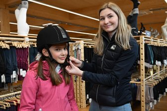 Warum das neue XXL-Pferdesportgeschäft bei Zwickau so gefragt ist - Beratung vor Ort: Pauline Schulz (10) testet mit Verkäuferin Lotte Kögler die Reithelme im neuen Pferdesportladen in Wildenfels.