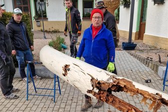Warum dem Gasthof zum Walfisch in Zwota im Moment sein mächtiges Wahrzeichen fehlt - Für den Abbau der marode gewordenen hölzernen „Walknochen“ waren mehrere Helfer nötig. In der Werkstatt von Michael Herold (vorn) erfolgt derzeit der Nachbau. Zum Hammerspektakel am 1. Mai soll sie wieder an ihrem Platz stehen.