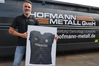 Warum der Hauptsponsor dem FSV Zwickau trotz Abstiegs die Treue hält - Betriebsleiter Christopher Reinhard mit einem gerahmten Dress aus der zweiten Halbserie der vergangenen Saison, als Hofmann Metall als Trikotsponsor beim FSV Zwickau einstieg.