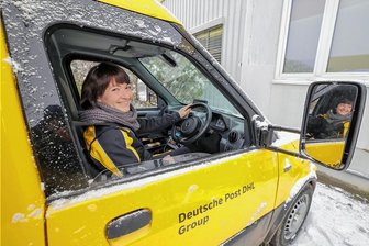 Warum der Paketbote im Landkreis Zwickau künftig auf der falschen Seite sitzt - Die Glauchauer Standortleiterin Stefanie Bohnig auf dem Fahrersitz des ersten Rechtslenker-Elektro-Paketzustellerfahrzeugs der Deutschen Post im Landkreis Zwickau. 
