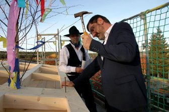 Warum der Schulbau einer Gemeinde im Vogtland länger dauert - Den symbolischen letzten Nagel schlug Bürgermeister Andreas Gruner ein. Jörg Pfeiffer trug den Richtspruch vor.