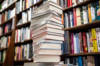 Warum die Jahresgebühr der Reichenbacher Bibliothek sachsenweit einen Spitzenplatz einnimmt - Bücherstapel in einer Bibliothek. Reichenbach dreht an der Gebührenschraube.