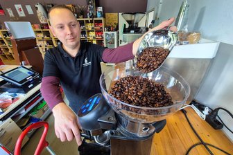 Warum die Kaffee-Preisexplosion einer Rösterei in Burgstädt keine Angst macht - Mitarbeiter Marcus Storch füllt Kaffeebohnen in eine Kaffeemaschine im Werksverkauf der Rösterei, der montags bis freitags von 10 bis 17 Uhr öffnet.