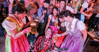 Warum die Wiesn nach Sachsen kam - Noch etwas lahm heute: "Schmidt und Band" treiben die Besucher der Chemnitzer "Wooosn" Abend für Abend auf die Bänke.