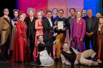 Warum ein Frosch aus Papier ein ganzes Ensemble verzückt - Schlussbild einer erfolgreichen Hausspielzeit: Inszenierungsteam und Ensemble freuen sich über die Auszeichnung mit dem Operettenfrosch des Bayerischen Rundfunks für "Der reichste Mann der Welt". 