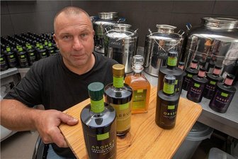 Warum ein Maurermeister aus Plauen jetzt auf Aronia-Gin setzt - Frank Sommer mit den Spezialitäten aus eigener Produktion: Verschiedene Aronia-Liköre und zwei Sorten vom Aronia-Gin mit besonderem Namen.