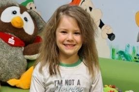 Warum eine Genossenschaft ihre Mieter mit Honig versorgt - Die fünfjährige Emily zeigt das Dankeschön-Plakat der Kinder.