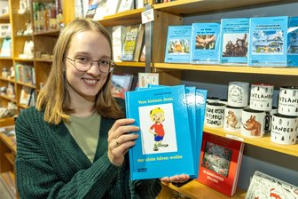Warum es im ersten Kinderbuch des ehemaligen Treueners Gerhard Gruner um Bakterien geht - Jessica Schulz von der Buchhandlung Buch und Kunst in Auerbach zeigt das neue Buch von Gerhard Gruner. Titel: „Vom kleinen Jens der nicht hören wollte.“
