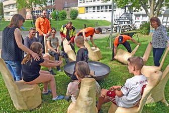 Warum Forst-Azubis in Flöha zwölf spezielle Gartenstühle spendieren - Die Azubis des Forstbezirks Chemnitz überbrachten der Jugendwohngruppe der Volkssolidarität Flöha Sitzmöbel. Corinna Reichenbach (l.) und Angela Gronwald (r.) und ihre Schützlinge probieren sie gleich aus.