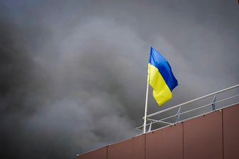 Warum im September so viele Ukrainer nach Sachsen kamen wie seit August 2022 nicht mehr - Die ukrainische Flagge inmitten des Rauchs nach einem russischen Raketenangriff in Dnipro.