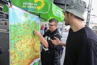 Warum Jung und Alt das 9-Euro-Ticket vermissen werden - Lukas Rietzschel (links) ist Fan des 9-Euro-Tickets und markiert auf der Deutschlandkarte am Stand der Bündnisgrünen mit Mitarbeiter Konstantin Scheffler am Hauptbahnhof, wohin er mit der Fahrkarte gereist ist. 