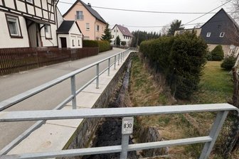 Warum kleine Stützwand zur größten Herausforderung wird - Nur von weitem sieht die Bachmauer "Am Erlbach" in Reichenbach mit dem neuen Geländer noch relativ gut aus. Die Mauer bröckelt jedoch mehr und mehr auseinander.