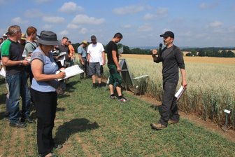 Warum Landwirte im Vogtland mehr Hafer anbauen sollen - Martin Sacher (rechts) erklärt Teilnehmern des Feldtages die Versuchsparzellen der Hafersorten.