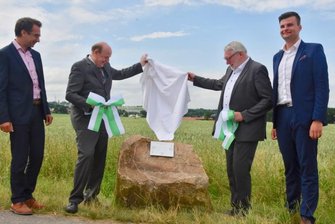 Warum Niederfrohna wächst und Mühlau schrumpft - Jens Hinkelmann und Landrat Christoph Scheurer vom Landkreis Zwickau sowie Mittelsachsens Landrat Matthias Damm und Steve Sarfert, stellvertretender Mühlauer Bürgermeister (von links), enthüllen einen Findling. Er soll die neu gezogene Landkreis- und Gemeindegrenze zwischen Zwickau und Mittelsachsen sowie Niederfrohna und Mühlau markieren. 