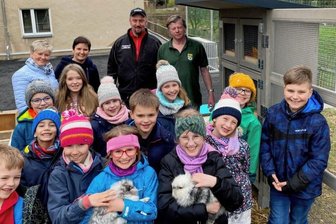 Warum Schüler in Hauptmannsgrün auch am Wochenende in die Schule gehen - Endlich sind Flauschi und Hoppel da. Die AG Tierfreunde der Hauptmannsgrüner Grundschule mit den beiden Löwenköpfchen am neuen Hasenstall - darüber freuen sich ebenso: Schulleiterin Undine Grimm, Lehrerin Katja Hommel, Zimmerermeister Lars Hölzel sowie Reiner Dittes von den Unterheinsdorfer Kleintierzüchtern (von links). 