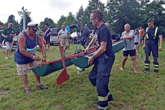 Warum schwimmt ein Silberpfeil unter statt über die Holzbrücke Hohenfichte? - André Zenker (li.), der spätere Sieger, lässt mit Unterstützung sein Eigenbauboot namens Gründonnerstag ins Wasser bringen.