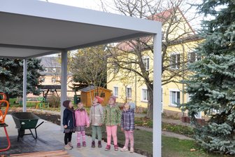 Warum sich Altmittweida trotz Überschuss um die Finanzen sorgt - Kinder der Tagesstätte „Bienenkorb“ bestaunen die neu erreichtete Sonnenschutz-Pergola.