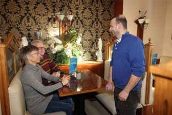 Warum sich ein griechischer Gastwirt aus Crimmitschau verabschiedet - Sie schauen immer nach dem Schlittschuhlaufen im griechisches Restaurant in Crimmitschau vorbei: Die Geraer Angela und Andreas Kühne im Gespräch mit Restaurantchef Theodoros Gianouchalidis (rechts).