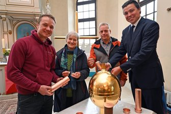Warum steckt ein USB-Stick im Kirchturm Rothenfurth? - Die Turmkugel wird bestückt: Metallbildner Thomas Müller (v. l.), Silke Eckardt und Dirk Otto von der Kirchgemeinde und Pfarrer Justus Geilhufe.