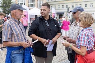 Was das Bündnis Sahra Wagenknecht im Erzgebirge bewegen will - BSW-Kandidat Willy Frost (2. v. l.) kommt auf dem Marktplatz in Annaberg auch mit Bernd Schmitt (l.) sowie Thomas und Gabrielle Müller in Gespräch.