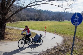 Was der E-Bike-Boom bewirkt: Wird das Vogtland jetzt zum Radlerland? - Die ersten Sonnenstrahlen künden vom nahenden Frühling und locken Radler hinaus in die Natur. Der Elsterradweg ist zwischen Plauen und Straßberg gut ausgebaut, das Netz insgesamt enthält jedoch viele Lücken. Im Bild: Juliane Schmidt mit ihrer Tochter Paula (8 Monate jung), die im Anhänger mitfährt.