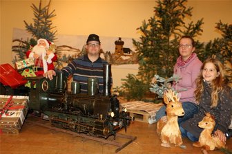 Was die Kürbitzer zum zweiten Advent alles auf die Beine stellen - Die Dampflok vor winterlicher Landschaft: Nancy Anders mit Töchterchen Lina und Nico Seidl präsentieren das Bühnenbild im Kürbitzer Saal.