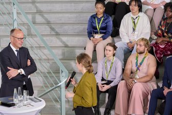 Was die neue Regierung für junge Menschen plant - Bundeskanzler Friedrich Merz (CDU, links) diskutiert mit Teilnehmern des internationalen Jugendcamps „Youth4Peace“ in Berlin.