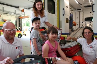 Was die neue Rettungswache in Geyer bietet - Tag der offenen Tür in der neuen Rettungswache in Geyer: Adrian und Juliane aus Thum haben sich von Rettungsassistentin Teresa Baum (r.), Notfallsanitäterin Sarah Klose (stehend) und Rettungsassistent Sven Schindler alles genau erklären lassen. 