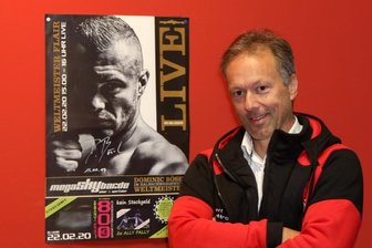 Was ein Spielhallenbetreiber mit einem Box-Champion zu tun hat - Sven Meyer neben einem Plakat, das den Profiboxer Dominic Bösel zeigt.
